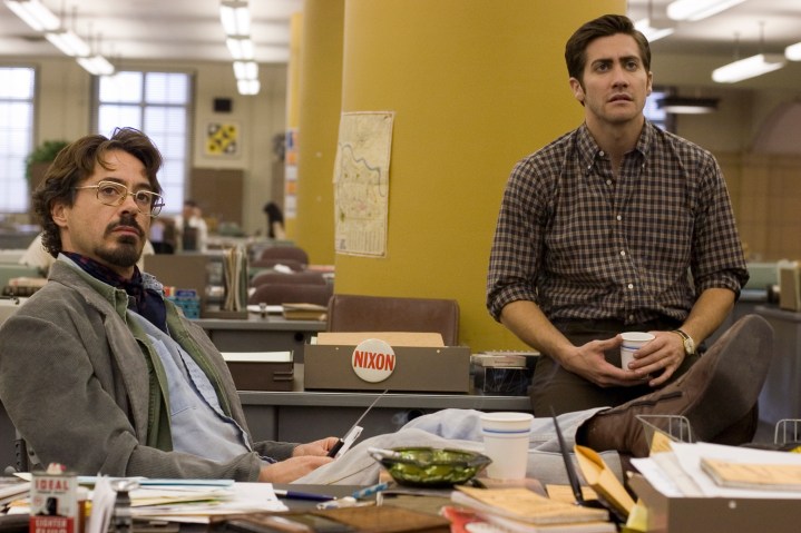 Robert Downey Jr. y Jake Gyllenhaal se sientan juntos en una oficina en Zodiac.