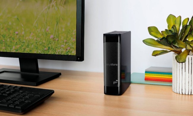 The WD Easystore 14TB External USB 3.0 hard drive on a desk next to a monitor and near a plant.