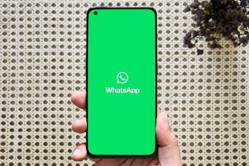 WhatsApp logo on a phone held in hand.
