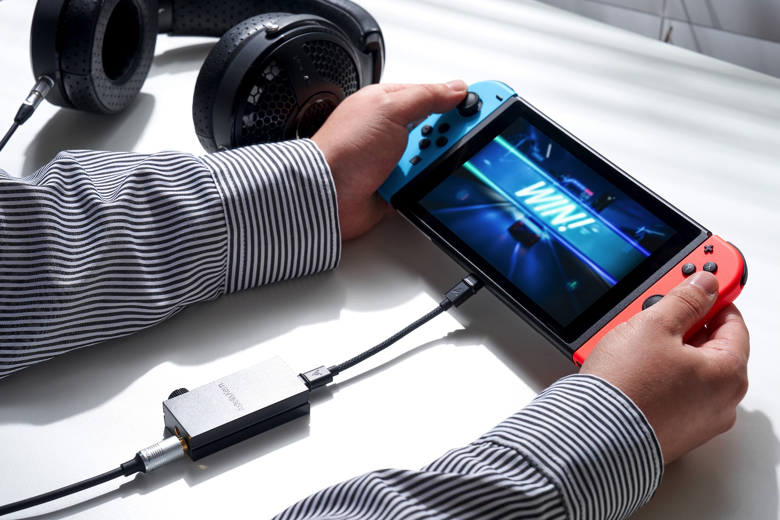 Astell&Kern HB1 Bluetooth DAC/amp seen with portable game console.