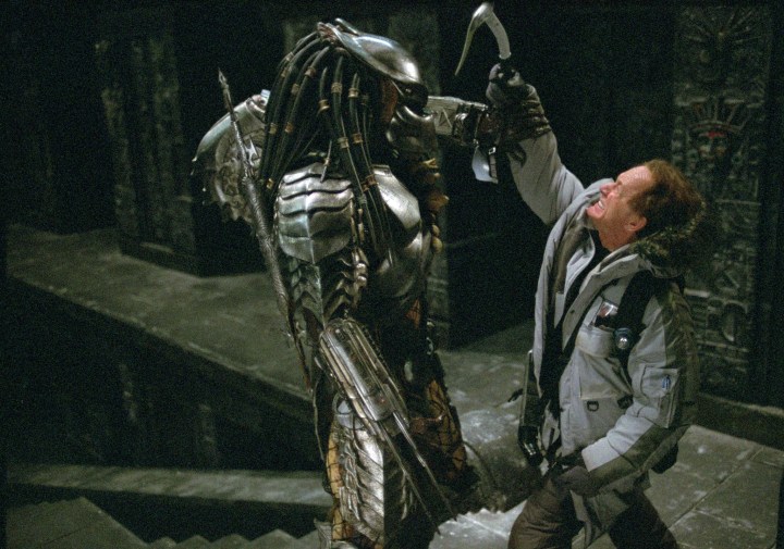 A Predator stops a human from hitting it with an axe in Alien vs Predator