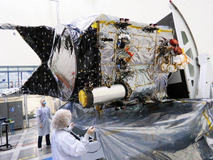 El transceptor de vuelo para la demostración de la tecnología de Comunicaciones Ópticas del Espacio Profundo de la NASA se puede identificar por su gran parasol en forma de tubo en la nave espacial Psyche, que se ve aquí dentro de una sala limpia en el Laboratorio de Propulsión a Chorro de la NASA en el sur de California.