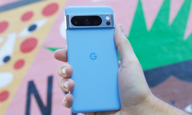 Someone holding the Google Pixel 8 Pro in front of a colorful background.