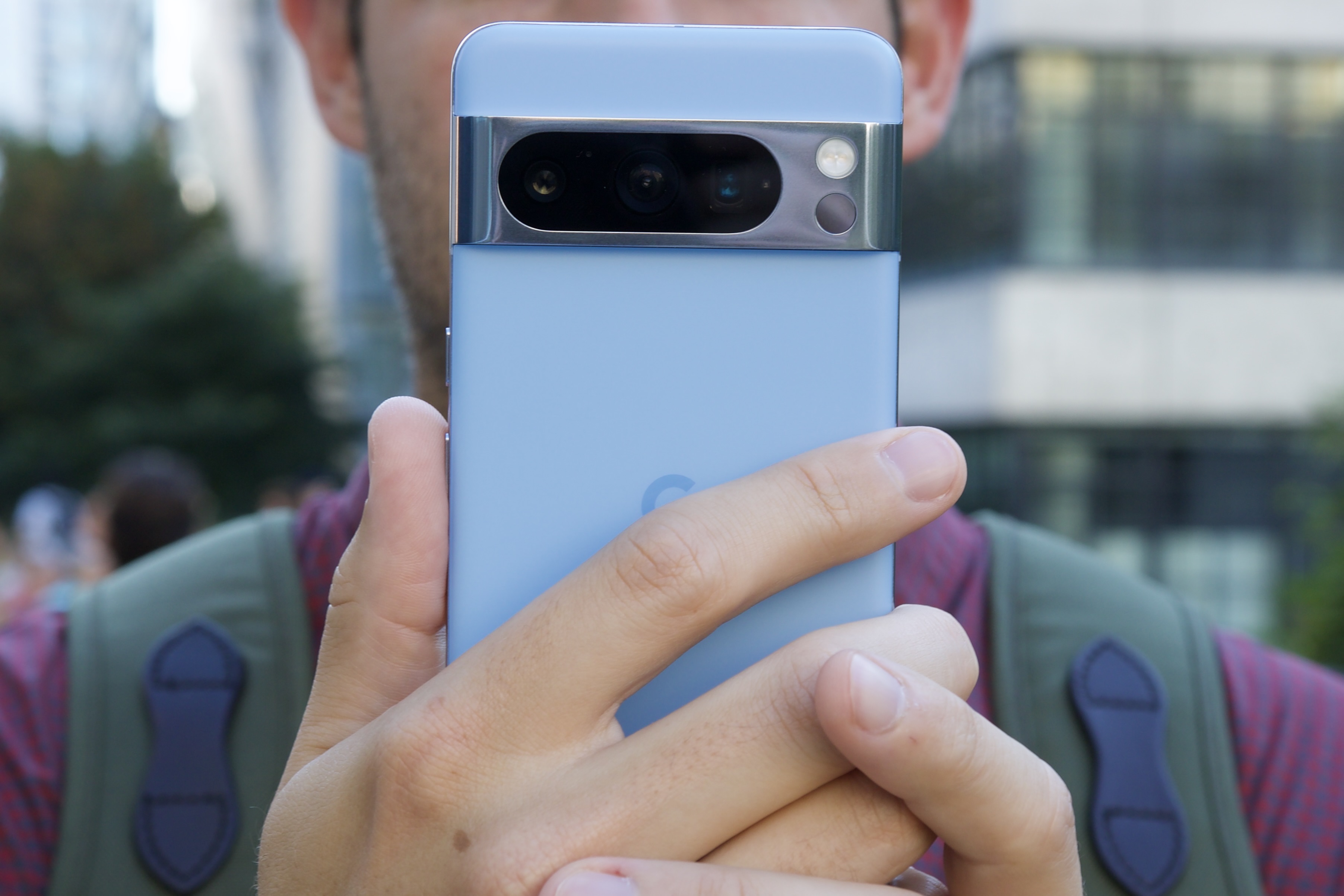 A person holding the Google Pixel 8 Pro in front of their face.