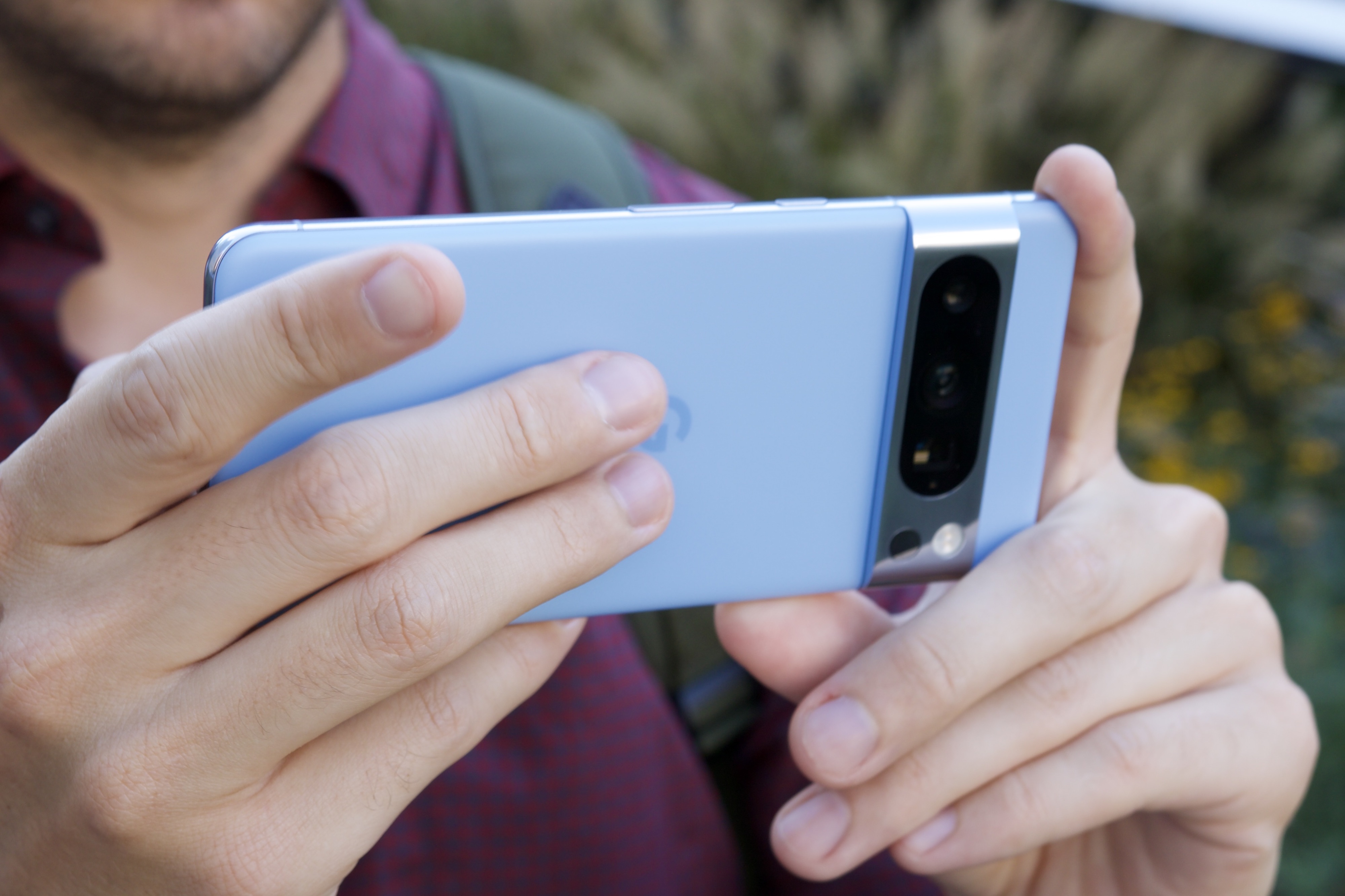 A person holding the Google Pixel 8 Pro horizontally.