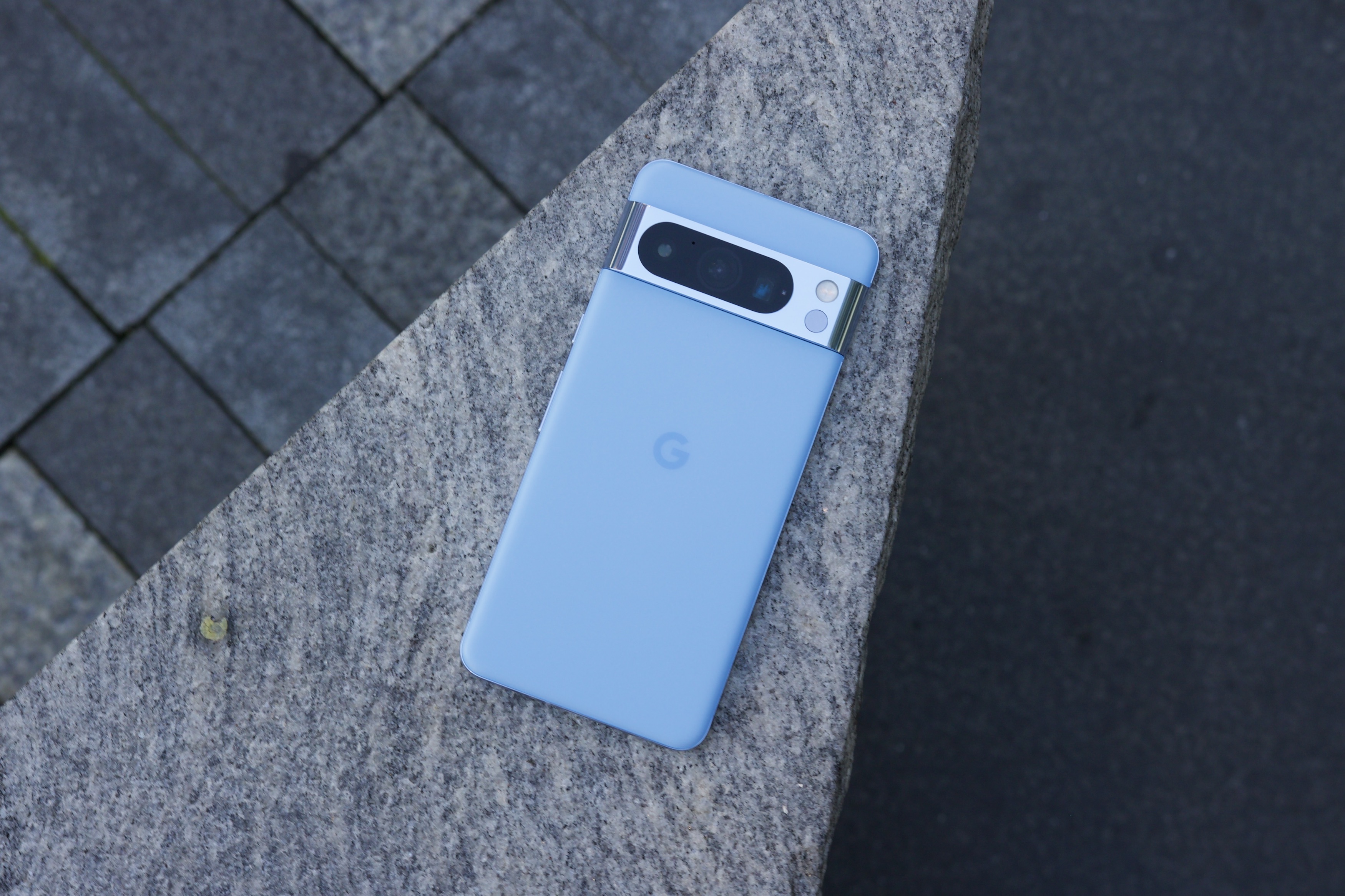 The Google Pixel 8 Pro laying face-down on a concrete structure.
