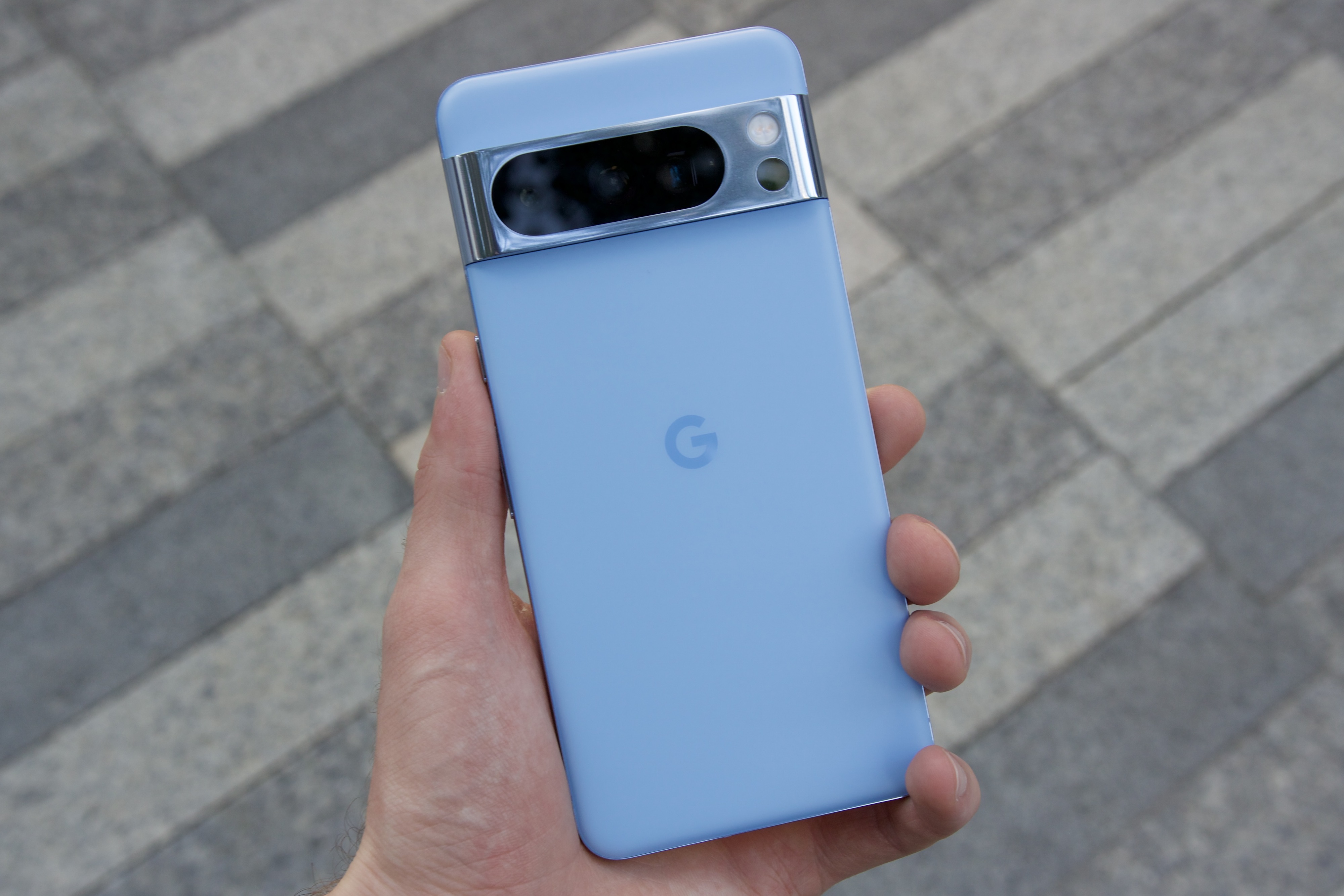 شخصی Google Pixel 8 Pro آبی را در دست گرفته است.