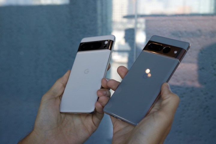 The Google Pixel 8 Pro and Google Pixel 7 Pro being held next to each other.