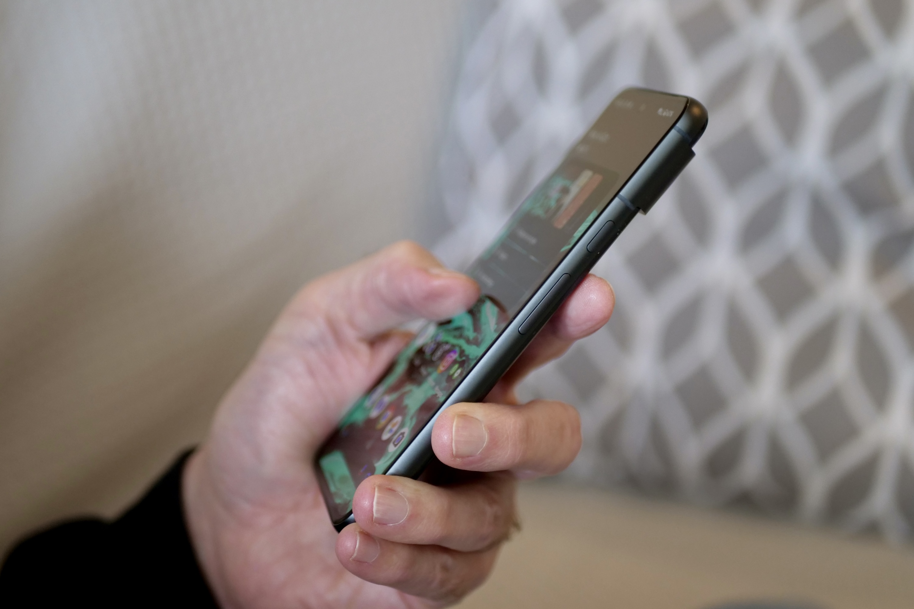 A person holding the Google Pixel 8, showing the side of the phone.
