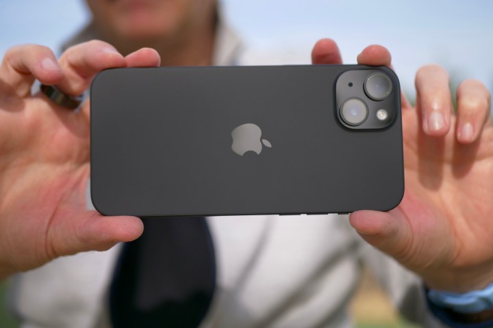 A person taking a photo with the Apple iPhone 15 Plus.