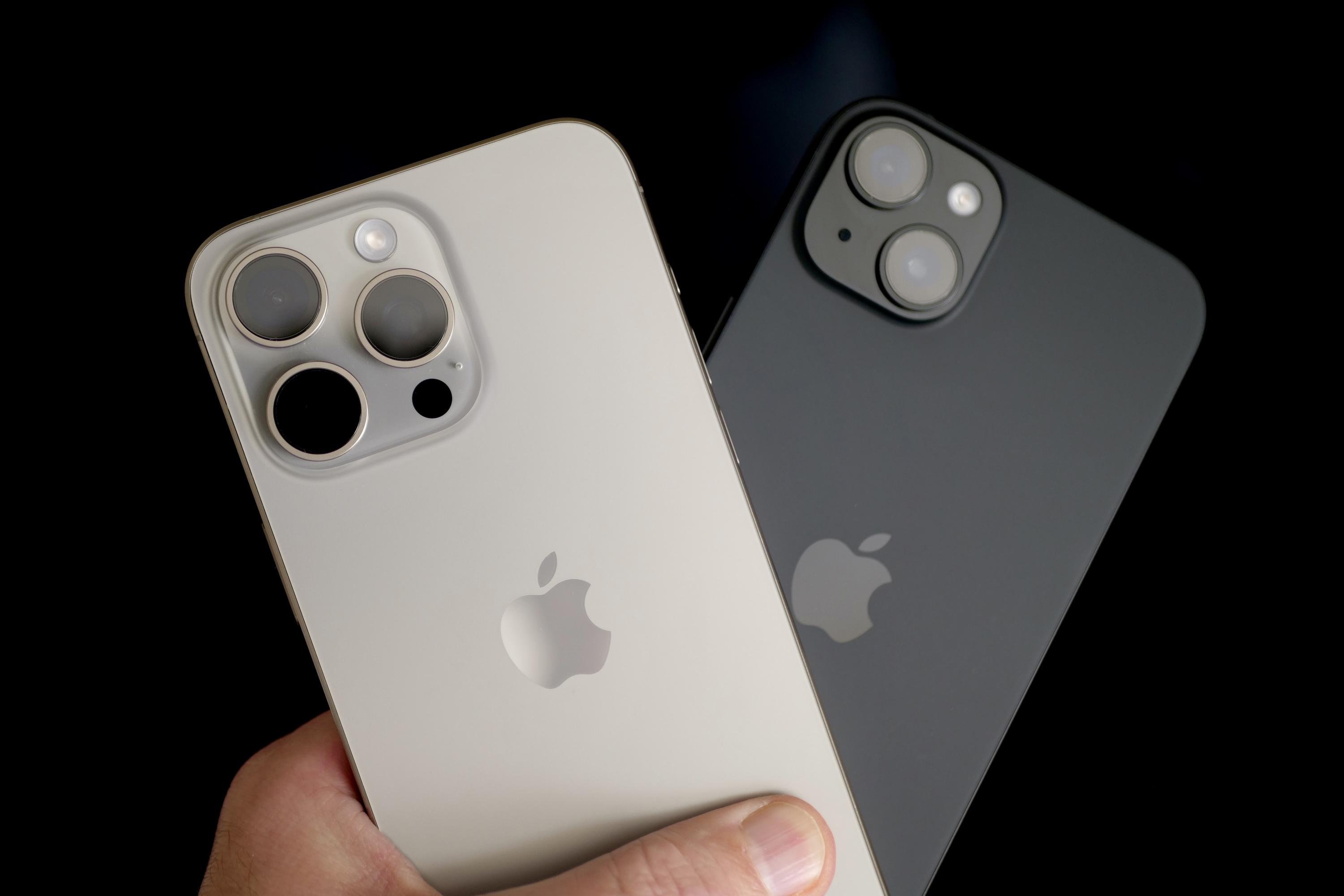 Una persona sosteniendo el Apple iPhone 15 Plus y el Apple iPhone 15 Pro Max.