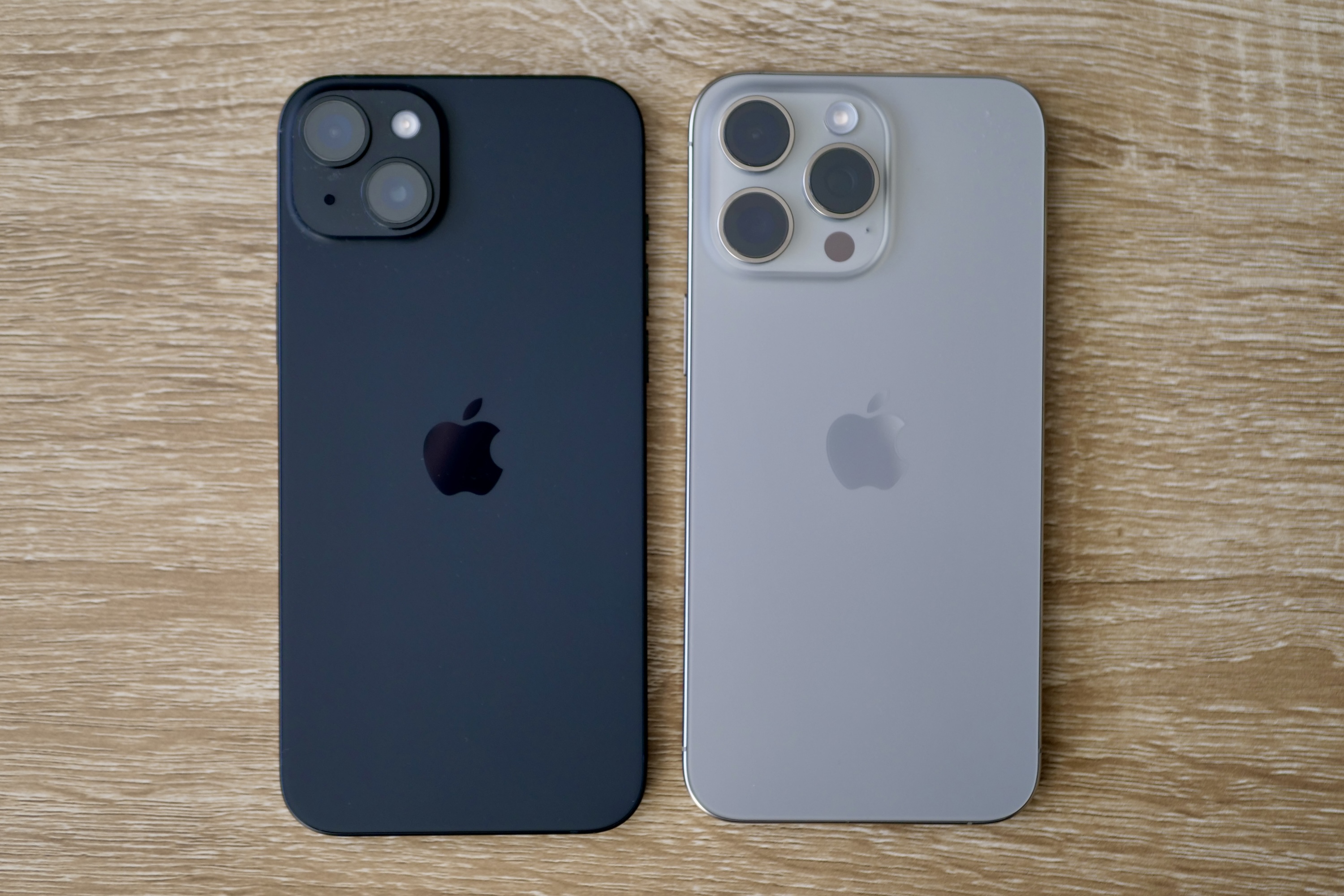 Apple iPhone 15 Plus and Apple iPhone 15 Pro Max seen from the back.