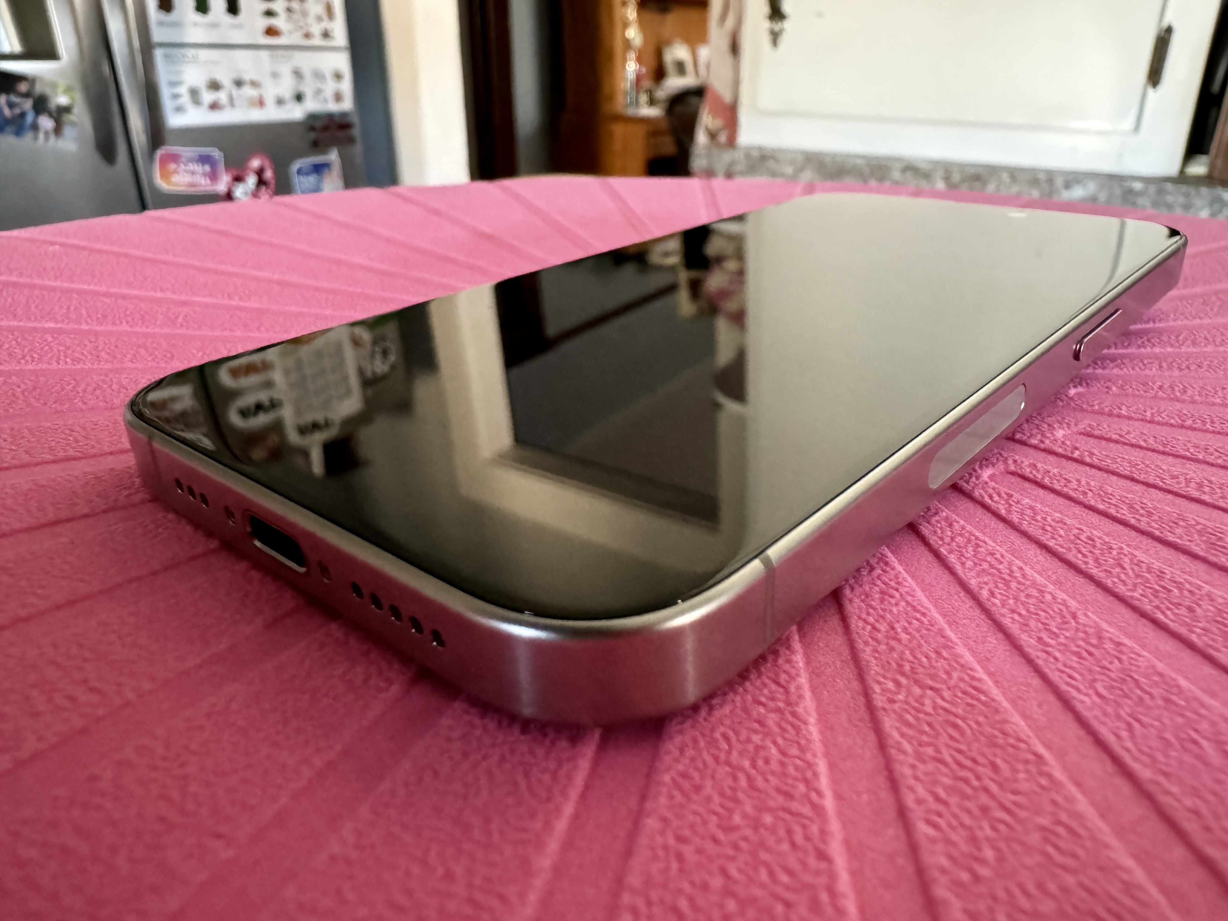 Doğal Titanyum iPhone 15 Pro'nun kavisli kenarları gösteren yakından görünümü.