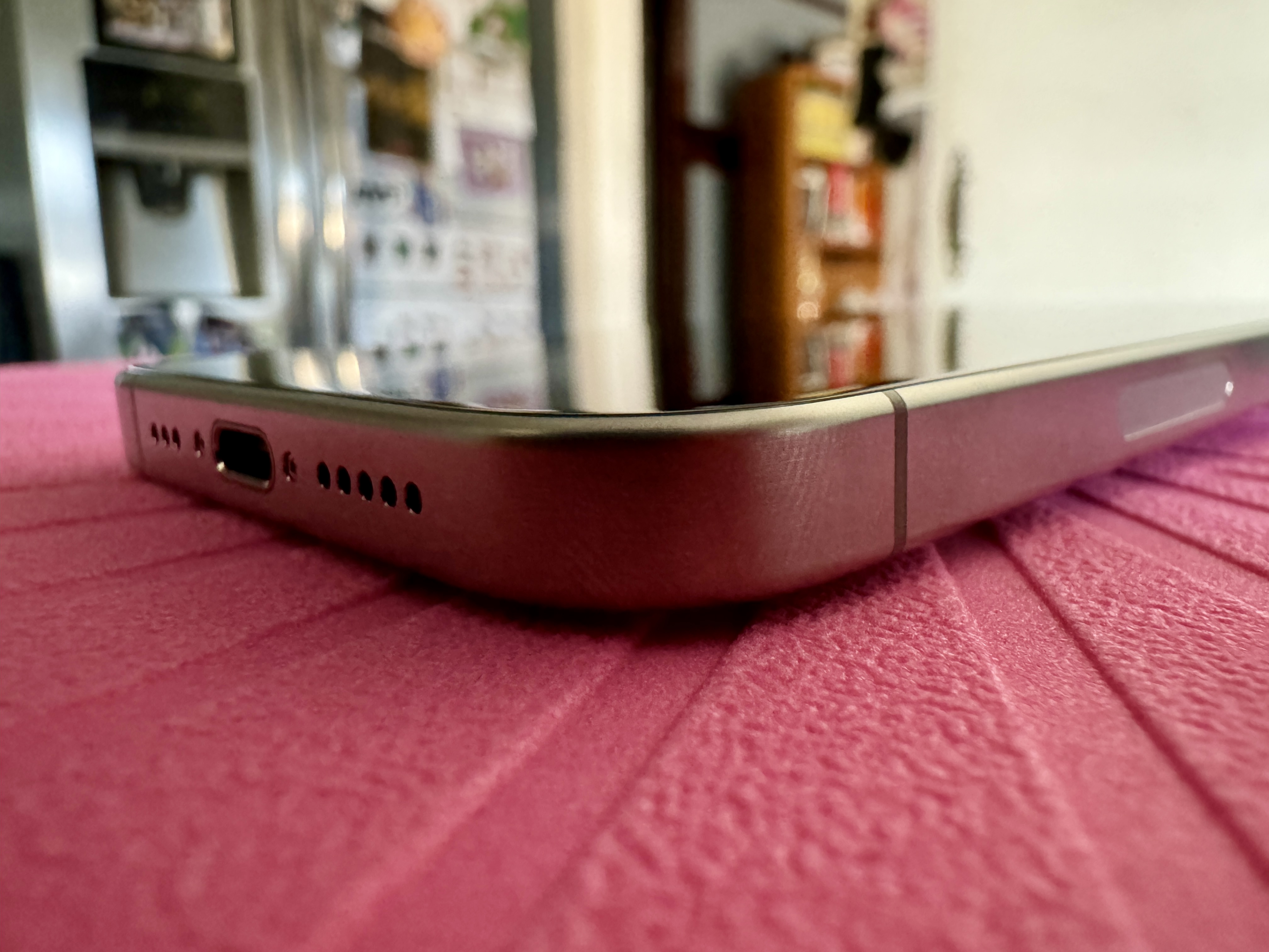 Natural Titanium iPhone 15 Pro showing curved edges in a closeup shot.