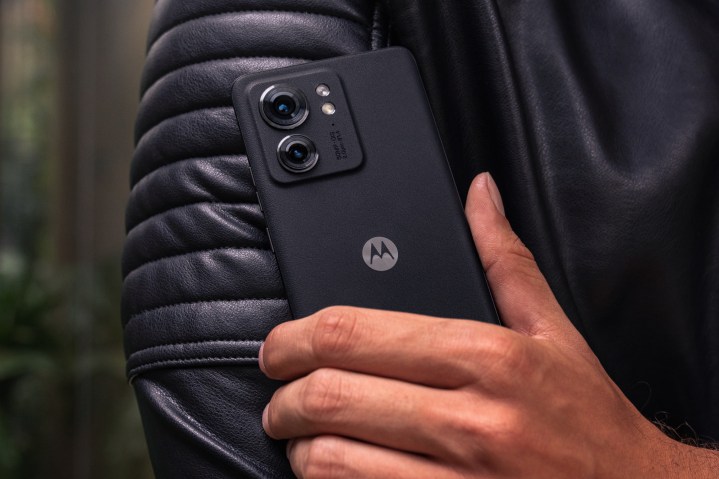 Siyah bir Motorola Edge (2023) akıllı telefon tutan bir kişi.