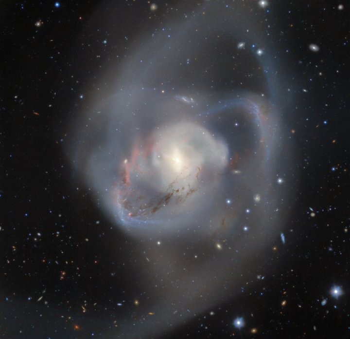 Gemini Sur, la mitad del Observatorio Internacional Gemini operado por NOIRLab de NSF, captura las secuelas de mil millones de años de una colisión de galaxias en doble espiral. En el corazón de esta caótica interacción, entrelazados y atrapados en medio del caos, se encuentra un par de agujeros negros supermasivos, el par más cercano jamás registrado desde la Tierra.