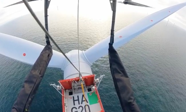 An Orsted drone drops off a delivery onto a wind turbine's platform.