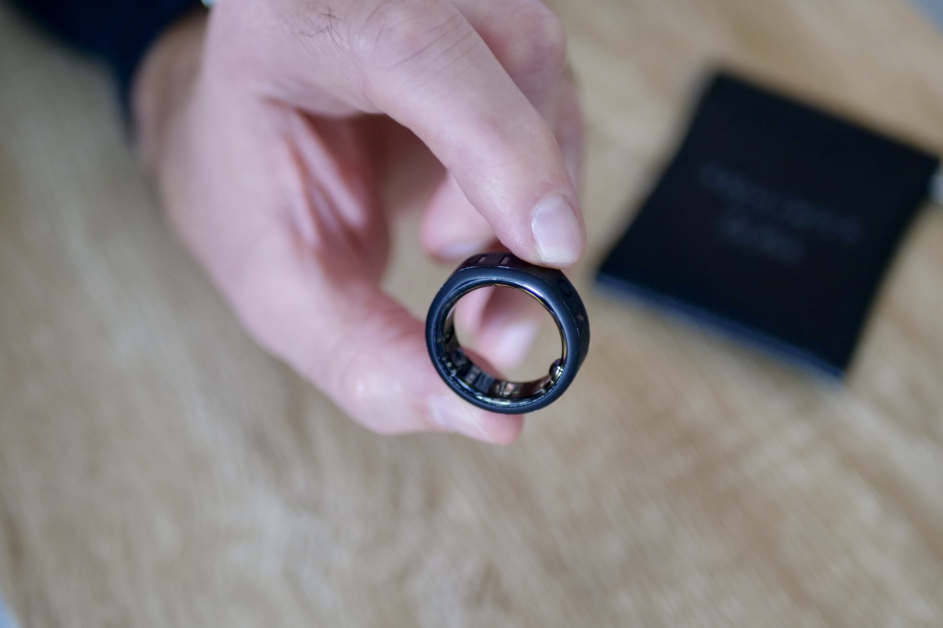 A person holding the Oura Ring in the Equinox Ring Cover.