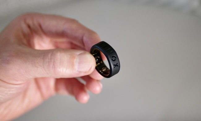 A person holding the Oura Ring in the Equinox Ring Cover.