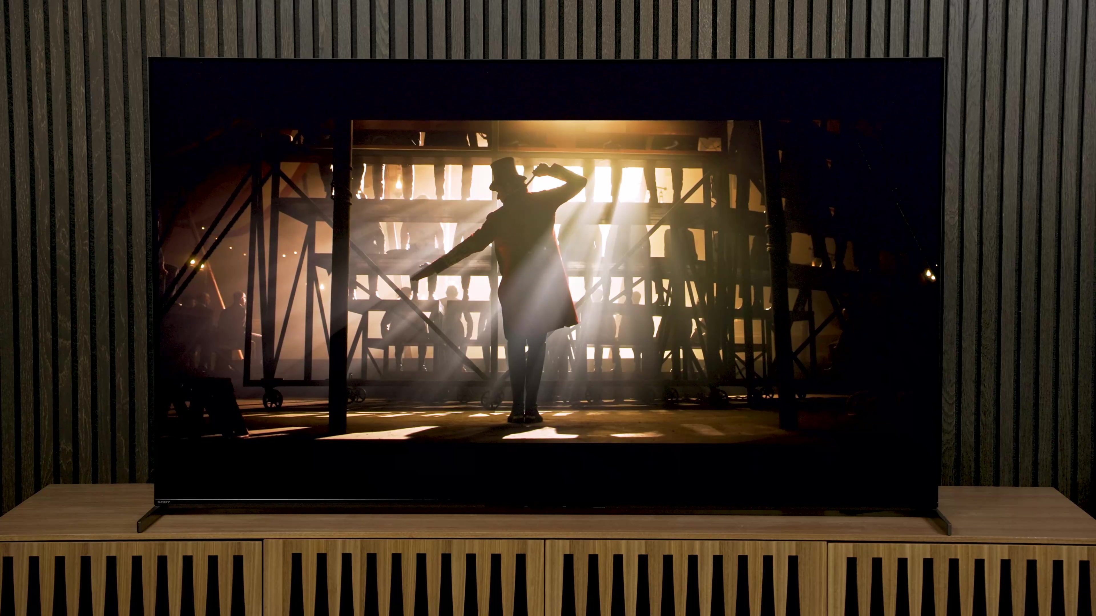 Light filters through wooden bleachers in The Greatest Showman on a Sony A95L QD-OLED.