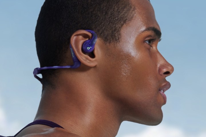 Man wearing Soundcore AeroFit Pro in Electric Purple with the optional neckband.