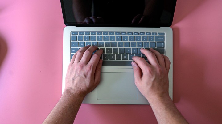 Draufsicht einer Person, die auf einem Surface-Laptop tippt.