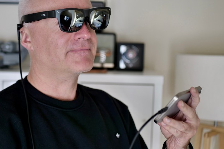 A person wearing the TCL RayNeo Nxtwear S XR glasses.