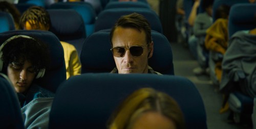 A man sits on a plane in The Killer.