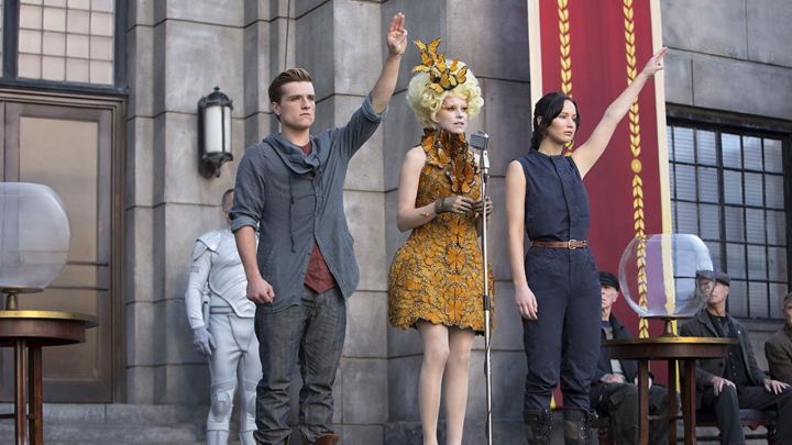 Josh Hutcherson, Elizabeth Banks y Jennifer Lawrence como Peeta, Effie y Katniss en el escenario de Los juegos del hambre en llamas.