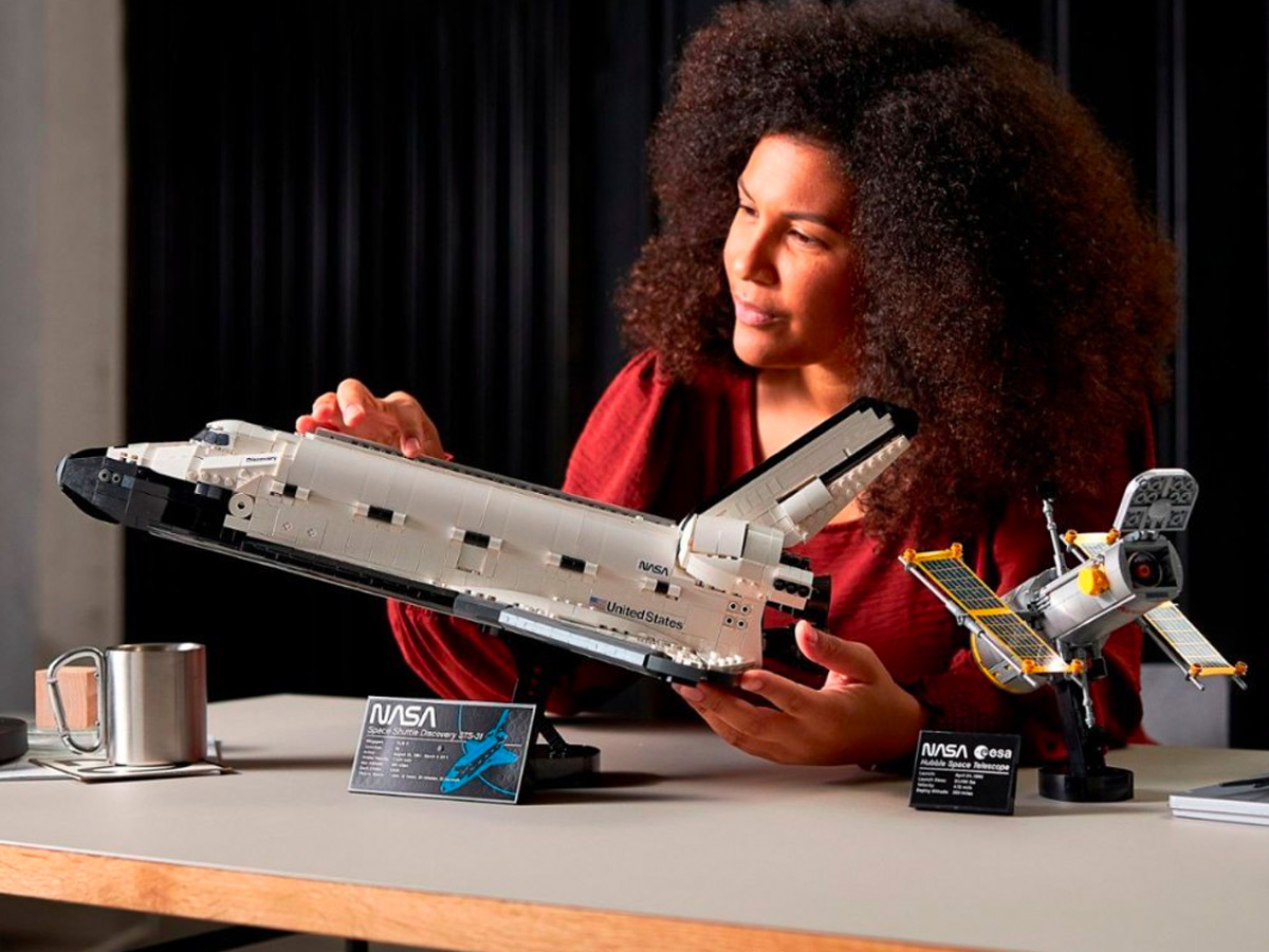 Una mujer arma los iconos de Lego del transbordador espacial Discovery de la NASA.