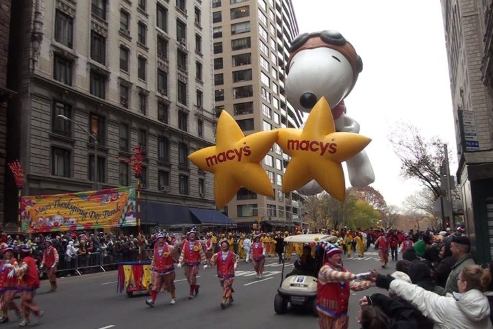 Les gens marchent dans la rue avec des ballons géants de parade à New York.
