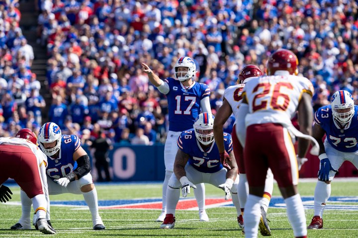 Josh Allen stands at the line of scrimmage and points.