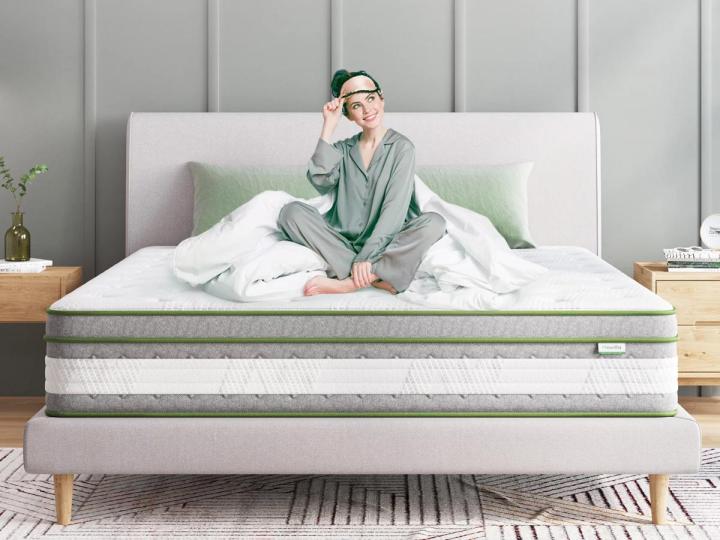 A woman sits on the Novilla 12-inch cool gel queen hybrid mattress.