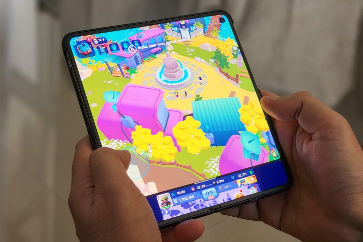 Two games running simultaneously on OnePlus Open held in hands.
