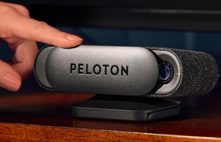 A hand sets up the Peloton Guide AI-powered personal strength training device.