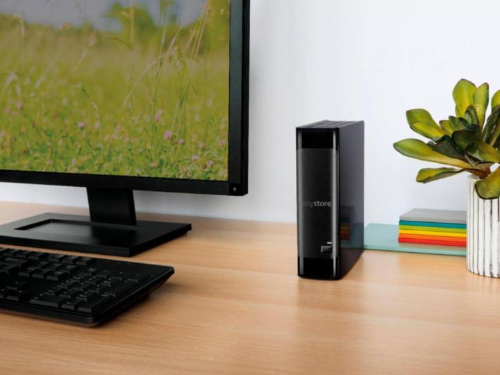 The WD Easystore USB 3.0 external hard drive alongside a monitor and keyboard on a desk.