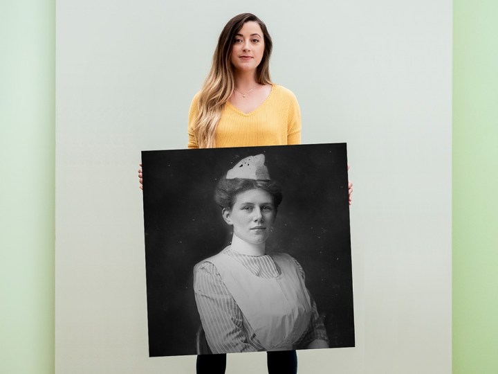 Woman holding up portrait of ancestor from AncestryDNA discovery