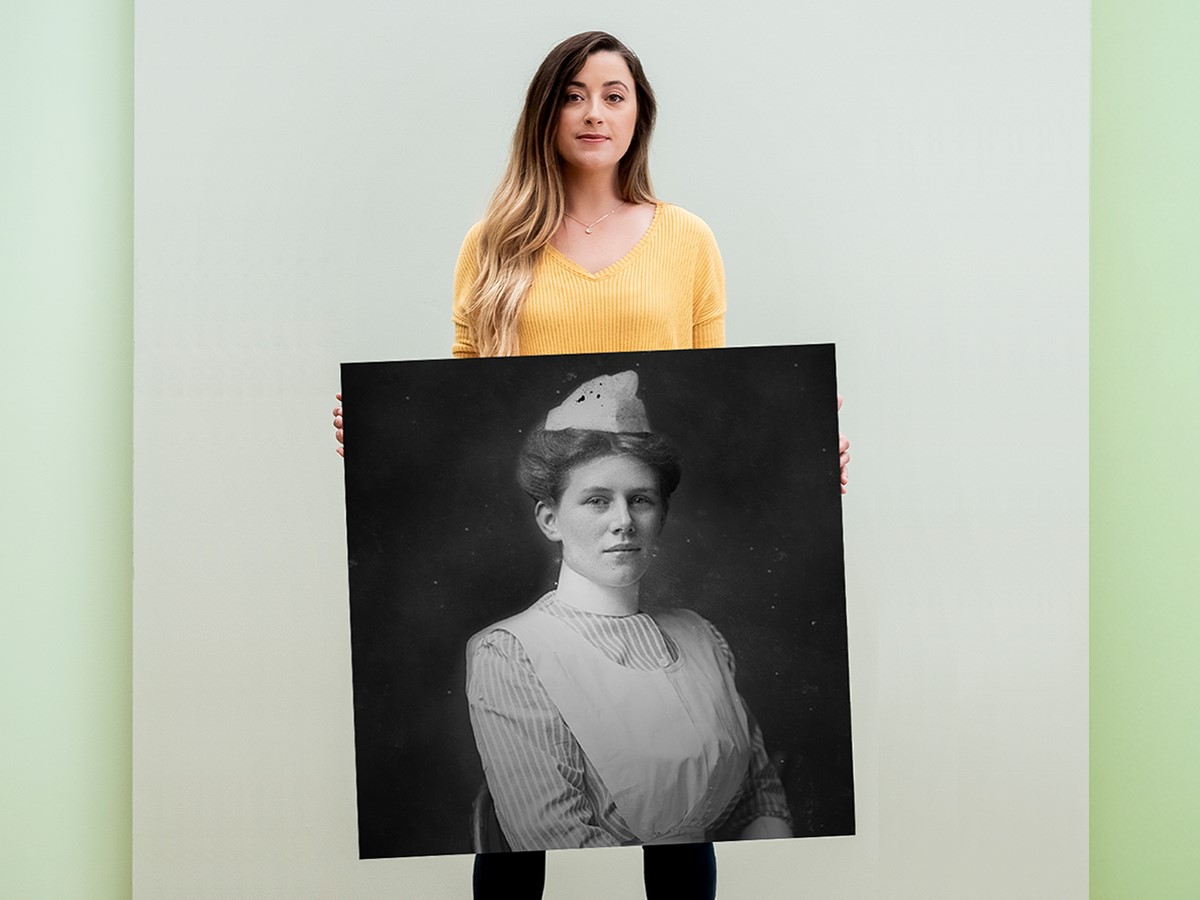 Woman holding up portrait of ancestor from AncestryDNA discovery