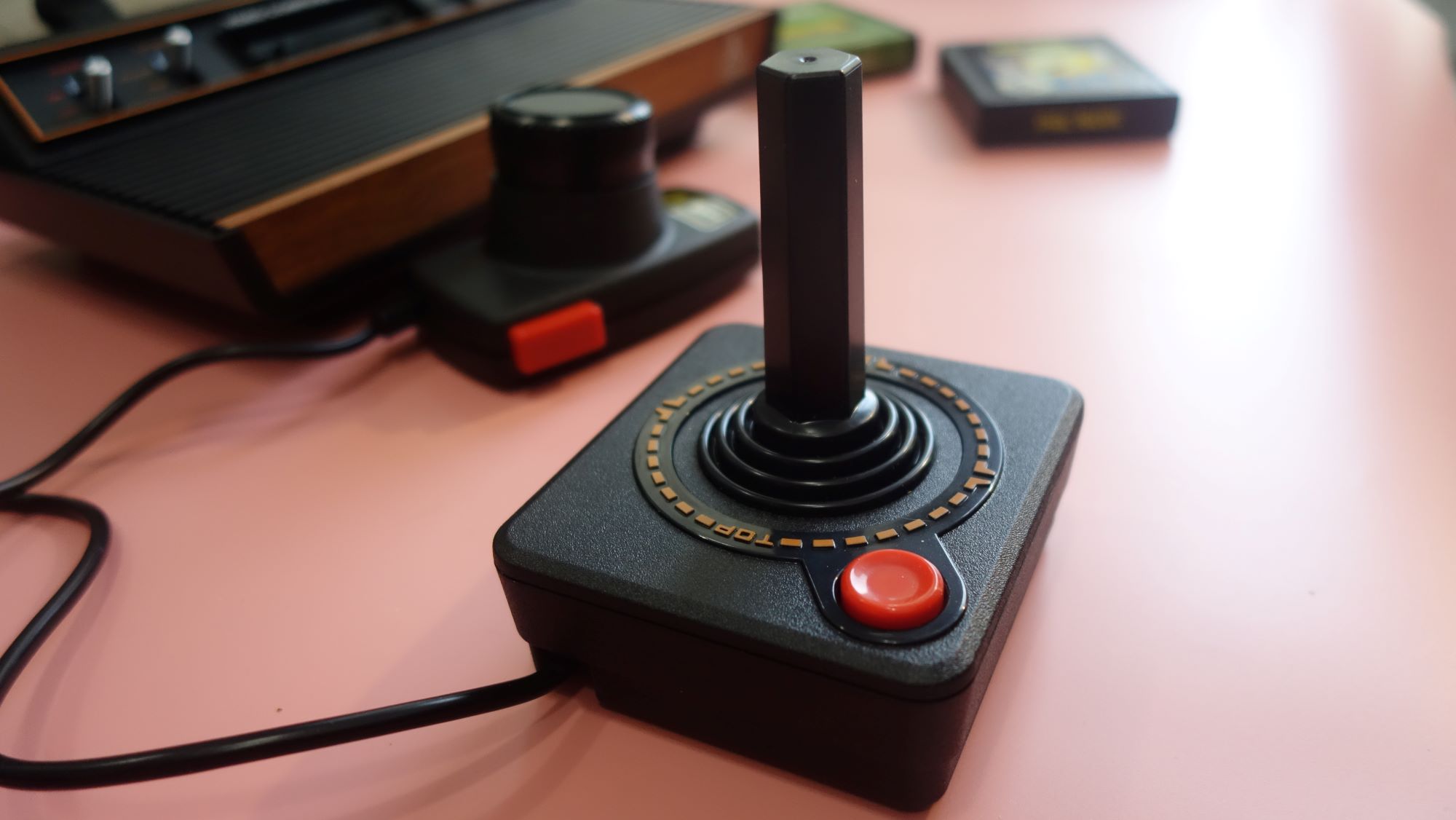 An Atari 2600+ joystick sits on a table.