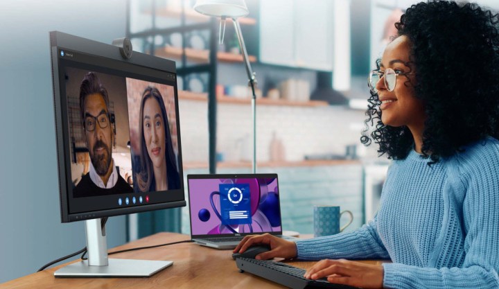 امرأة تستخدم جهاز كمبيوتر محمولًا متصلاً بشاشة مؤتمرات فيديو Dell 24.