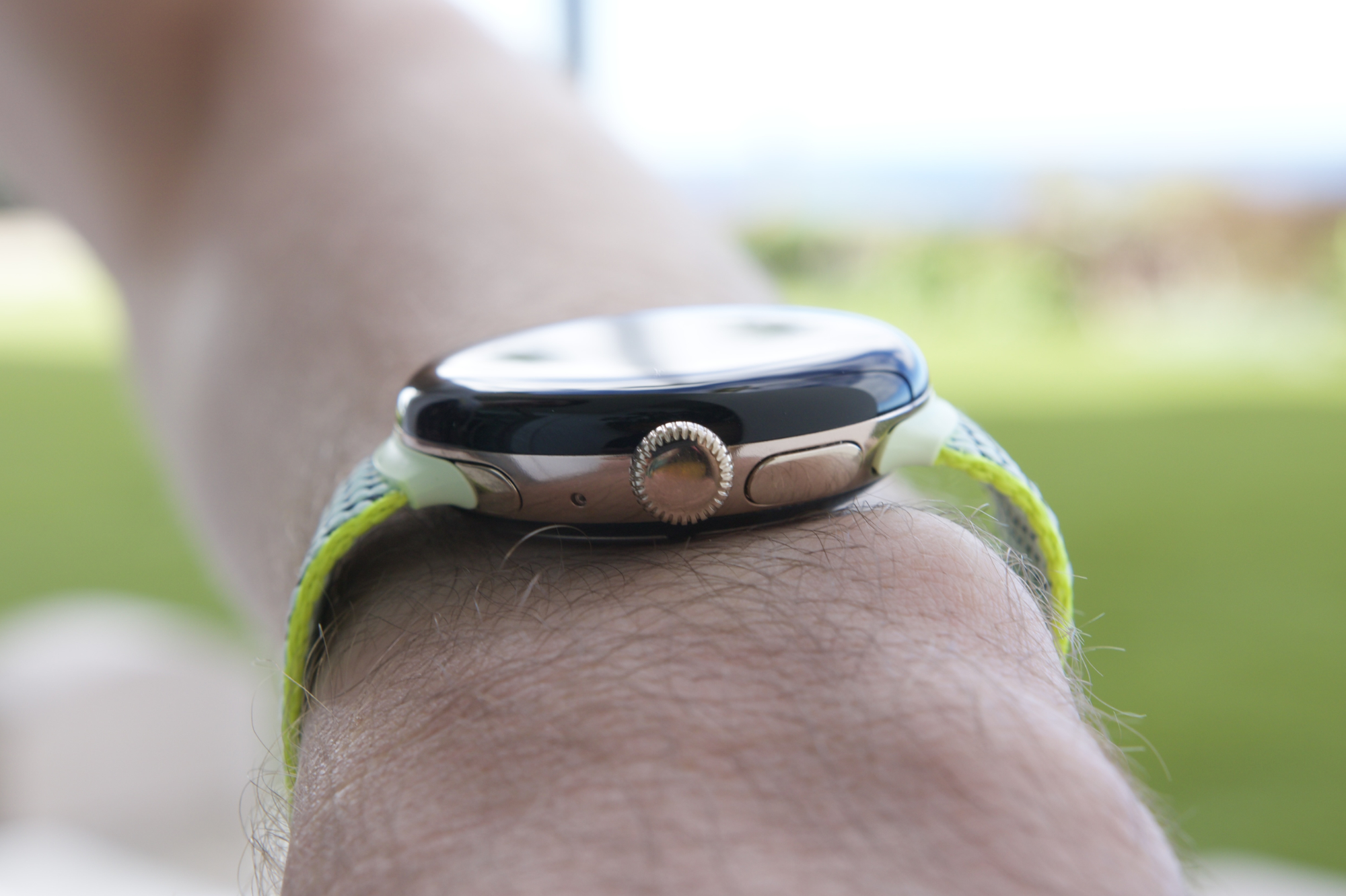 A close-up view of someone wearing the Google Pixel Watch 2, showing the rotating crown.