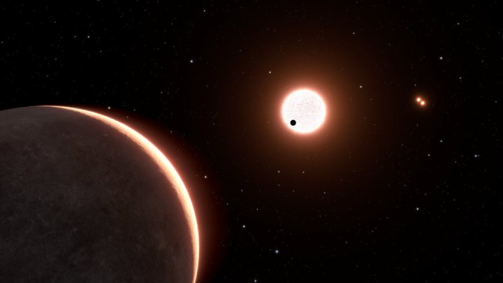 Este es un concepto artístico del exoplaneta cercano, LTT 1445Ac, que tiene el tamaño de la Tierra. El planeta orbita alrededor de una estrella enana roja. La estrella se encuentra en un sistema triple, con dos enanas rojas en órbita cercana que se ven en la parte superior derecha. El punto negro frente a la estrella en primer plano es el planeta LTT 1445Ab, transitando por la cara de la estrella. El exoplaneta LTT 1445Ac tiene una temperatura superficial de aproximadamente 500 grados Fahrenheit. La vista es desde 22 años luz de distancia, mirando hacia nuestro Sol, que es el punto brillante en la parte inferior derecha. Algunas de las estrellas de fondo forman parte de la constelación de Boötes.