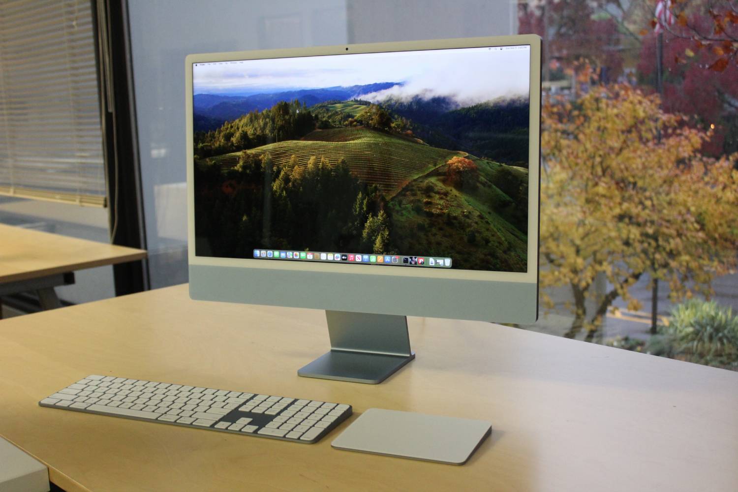 एक विंडो के सामने iMac का डिस्प्ले।