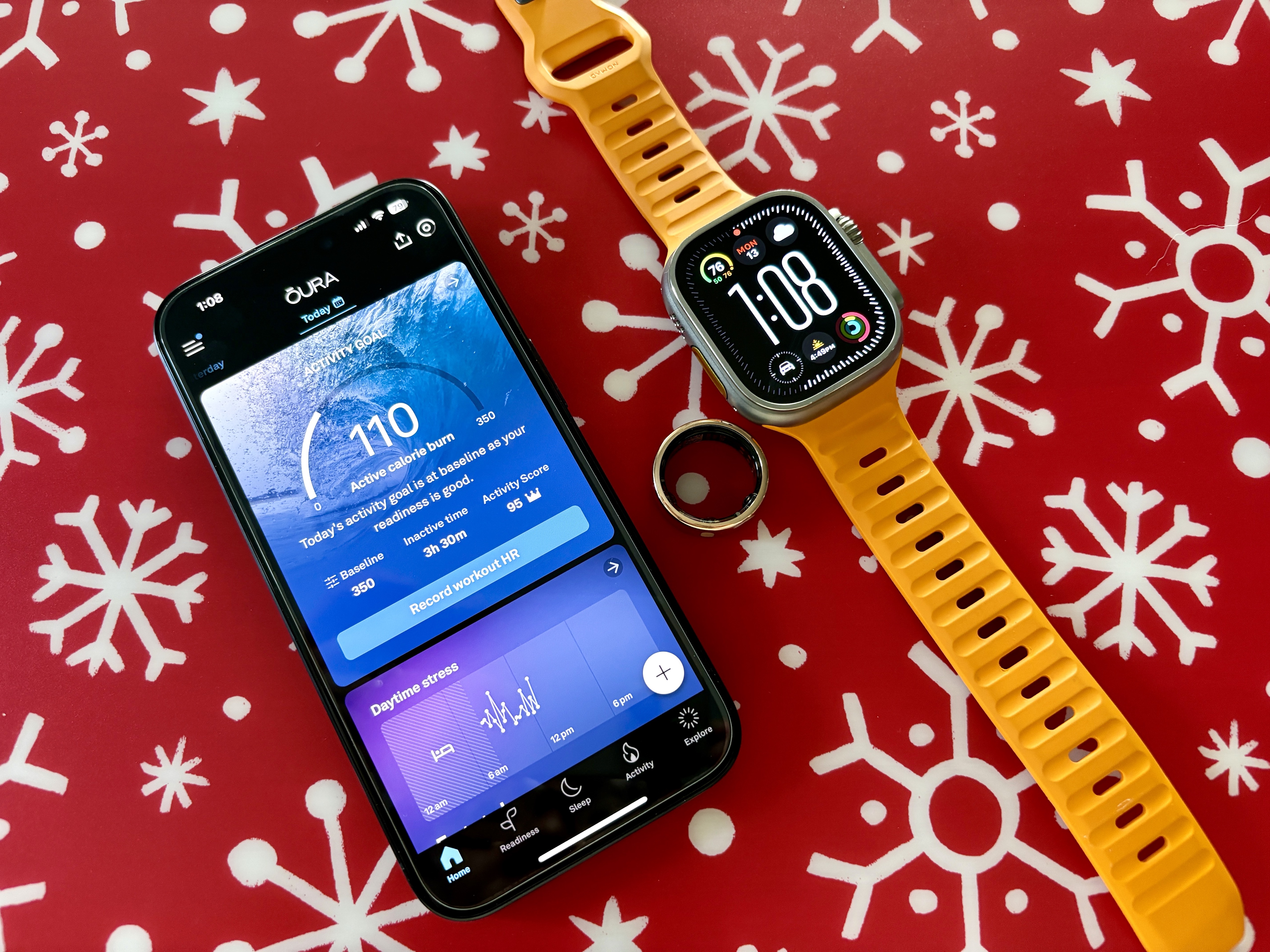 Oura Ring ve yanında Apple Watch Ultra'nın yer aldığı Oura uygulamasını gösteren iPhone 15 Pro.