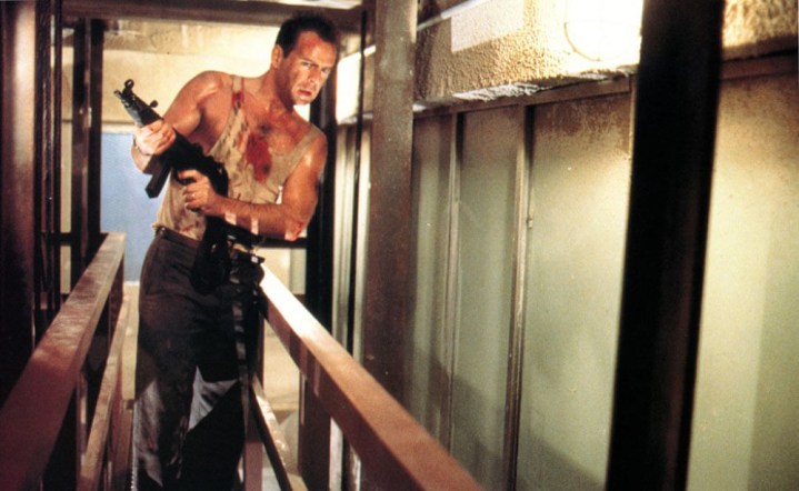 John McClane holds a gun in Die Hard.