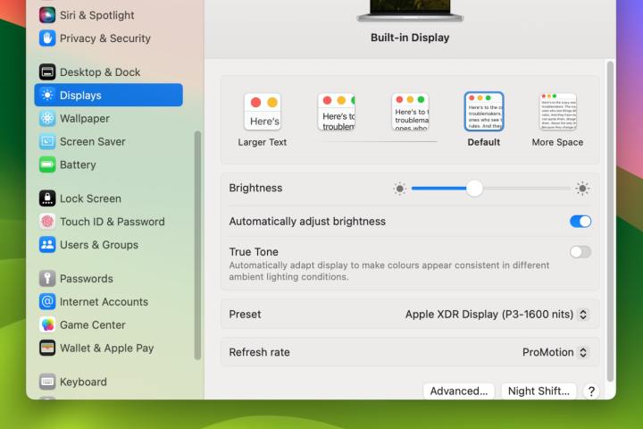 The Settings app in macOS Sonoma showing an option to automatically adjust screen brightness.