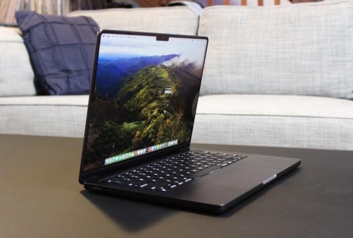 Il MacBook Pro aperto su un tavolo davanti a un divano.