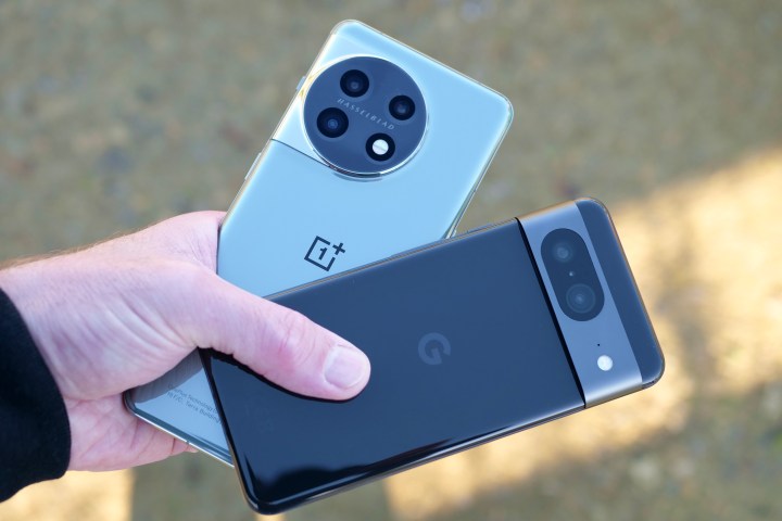 A person holding the OnePlus 11 and Google Pixel 8.
