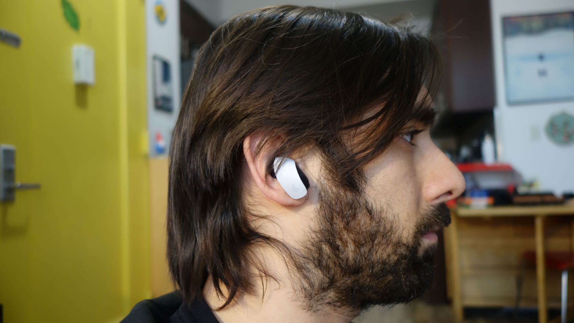 A Pulse Explore earbud sits in a man's ear.