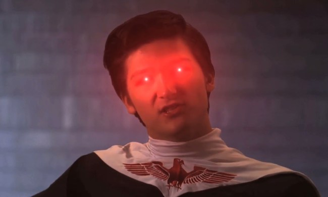A man with his head tilted to the side, red lasers coming out of his eyes in a scene from The Diabolical Schemes of Thadeus Jackson.